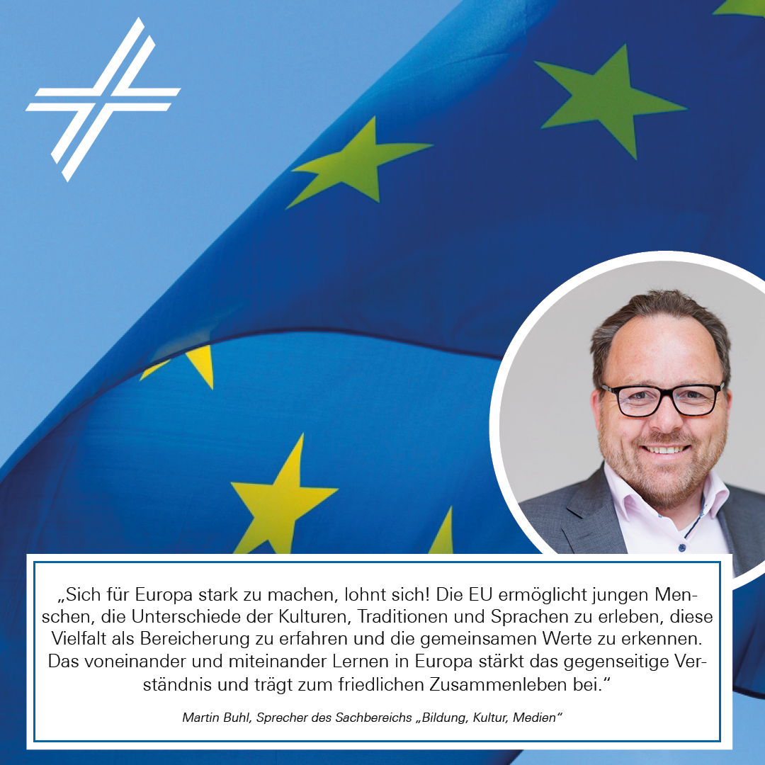 Europawahlstatement von Martin Buhl, im Hintergrund ist die EU-Flagge vor blauem Himmel und dem ZdK-Kreuz
