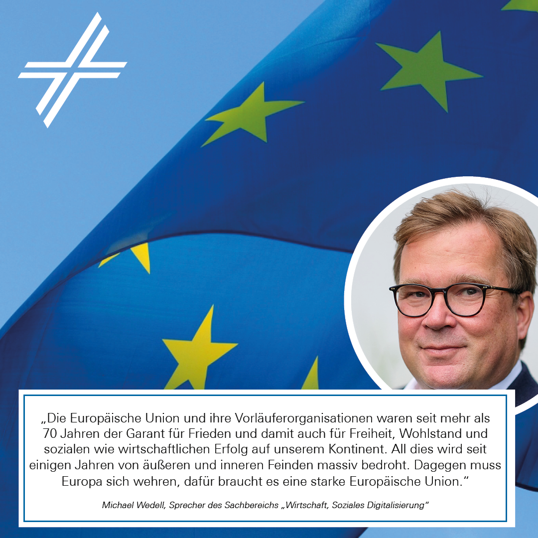 Europawahlstatement von Michael Wedell, im Hintergrund ist die EU-Flagge vor blauem Himmel und dem ZdK-Kreuz
